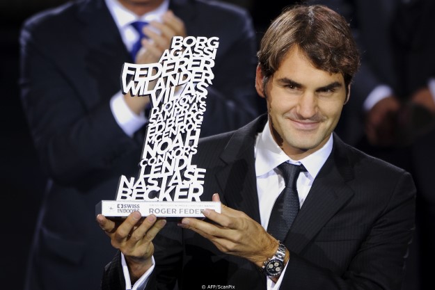 TOPSHOTS Swiss tennis player Roger Federer (R) holds the trophy during the Numer 1 History-Award ceremony at the Swiss Indoors ATP tennis tournament on November 1, 2011 in Basel.    TOPSHOTS / AFP PHOTO / FABRICE COFFRINI